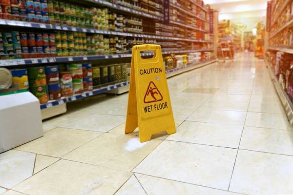 A caution wet floor sign in a grocery store aisle. Slip and fall accidents in Las Vegas are common in businesses.