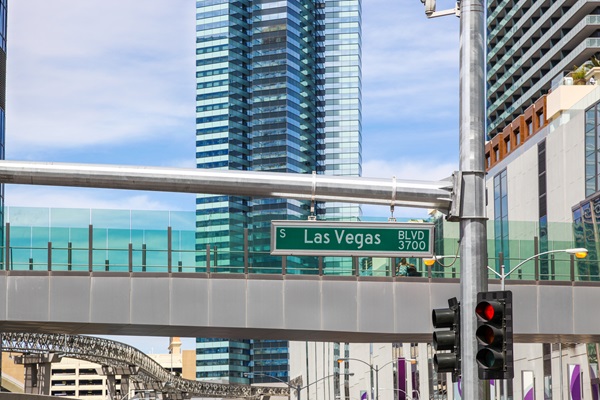 Street sign for Las Vegas Boulevard with modern high-rise buildings in the background.